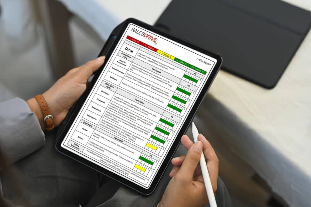 person holding a tablet displaying a SalesDrive profile report, showcasing insights for the partner sales acceleration program