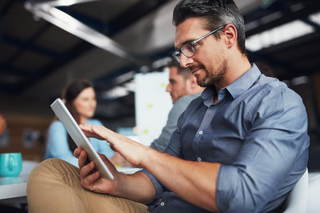 business consultant holding a tablet, reviewing sales partner program options